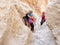 Extreme athlete preparing young atlete to descending with equipment for rappel in mountains of Judean Desert, near Rahaf stream,