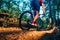 Extreme biker riding his bicycle downhill while wearing no safety equipment while hitting the brakes hard on a dirt trail