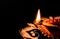 Extreme close up of beautiful earthen lamp and rangoli on black background with copy space in the left. diwali concept