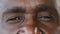 Extreme close up body part human male wrinkled face african american senior elderly adult man with dark iris eyesight