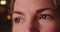 Extreme close up of Caucasian woman\'s brown eyes at night on urban street