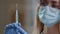 Extreme close up details woman doctor in protective medical face mask medical gown holding syringe for injection covid19