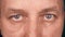 Extreme close up eyes of adult caucasian man. Front view of man face. Man looking to camera. Male sight freeze forward.
