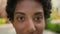 Extreme close up female face cropped African American ethnic girl woman young healthy lady close-up looking at camera