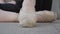 Extreme close-up of female foot in pointes standing up on tiptoe. Unrecognizable Caucasian female ballet dancer sitting