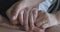 Extreme close-up of female hands wearing wedding rings caressing each other. Unrecognizable gay female couple stroking