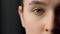 Extreme close up of half face shot of serious female face indoors. Closing eyes.