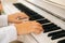 Extreme close-up hands of unrecognizable female musician performer playing on classical piano at home enjoying gentle