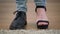 Extreme close-up of male caucasian feet stomping. One leg in men\'s boot, other one in women\'s high heel shoe. Intersex