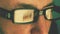 Extreme close up man face eyes glasses. Reflection from computer laptop screen in fashion glasses. Caucasian white man