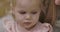 Extreme close-up of sad little Caucasian girl looking down. Portrait of cute gloomy child with beautiful grey eyes and