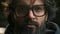 Extreme close up serious calm Arabian male face in eyeglasses looking at camera portrait headshot Muslim guy bearded