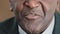 Extreme close up talking mouth of old senior biracial businessman, face part of speaking male wrinkled mature African