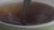 Extreme close-up of teaspoon mixing hot drink in cup. Unknown person dissolving sugar in tea. Beverage, brewing, kitchen