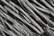 Extreme close up, top down view of bundels of grey colored, twisted polypropylene macro fibers for concrete reinforcement on black