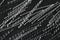 Extreme close up, top down view of macro polypropylene sinusoidal fibers for concrete reinforcement on black stone background