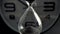 Extreme close up of a transparent hourglass with flowing black sand on blur dial background. Old classic timer. Time