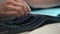 Extreme close-up of unrecognizable man assembling disassembled keyboard after cleaning of dirt and dust. PC user inserts