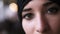 Extreme close-up of a young middle eastern muslim woman in black hijab opening dark brown eyes and looking to the camera