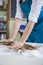 Extreme Closeup of Hands of Female Professional in Apron Rolling Out a Piece of Clay