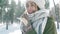 Extreme closeup portrait of beautiful smiling woman in woolen cap and long warm scarf in snowy winter park at frozzy