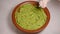 Extreme closeup top view of avocado smash rotating. Traditional tasty sauce guacamole. Adding onion