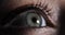 Extreme closeup view of woman\'s opening beautiful eye with green iris in dark.