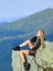 Extreme concept. On edge of world. Woman sit on edge of cliff in high mountains landscape background. Hiking peaceful
