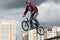 Extreme cycling.A dangerous trick on a bicycle against the backdrop of the city.A man