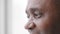 Extreme facial close up mature african middle aged man 50s male eyes with wrinkles looking in distance out window