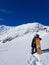 Extreme female snowboarder poses with her board before riding snowy mountain.