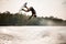 Extreme guy having fun on wakeboard jumps over splashing river water