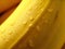 Extreme macro illustration of piece of banana in zoom. Water droplets are on the banana.