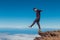 Extreme man standing and balancing on high mountain cliff edge.