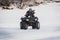 extreme Moto rider in gear on the ATV in the winter in the snow