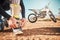 Extreme, motorcycle and man tying laces in nature for adventure, holiday and race in the countryside. Start, travel and