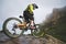 Extreme mountain bike sports athlete man in helmet riding outdoors against a background of rocks. Lifestyle. Trial