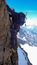 Extreme mountain climber on an exposed and vertical rock and snow face on his way to a high alpine mountain peak