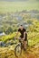 Extreme mountain cyclist riding bike on rocky trail at sunshiny day.