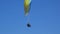 Extreme paraglider flying against a clear blue sky, sunbeam shines into camera. Paraglide flight experience skydive