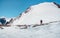 Extreme recreation and mountain tourism. A male hikers down the mountain path. In the background, large snow-capped mountains.