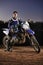 Extreme sport, portrait and man with off road motorcycle, confidence and gear for competition, race or challenge