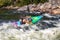 Extreme sport rafting whitewater kayaking. Guy in kayak sails mountain river