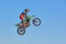 Extreme sports background - silhouette of biker jumping on motorbike on sunset, against the blue sky