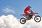 Extreme sports background - silhouette of biker jumping on motorbike on sunset, against the blue sky with clouds