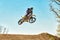 Extreme sports, motorcycle jumping. Motorcyclist makes an extreme jump against the sky.