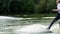 Extreme surprised businessman in a suit with a tie and sunglasses rides on wakeboard on a lake