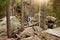 Extreme tall young woman going along wooden stick, finding her balance, spending time in harmony with nature, being around forest