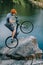 extreme trial biker balancing on back wheel on rocky cliff