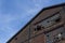 Extreme up angle view of abandoned industrial brick building with broken window panes